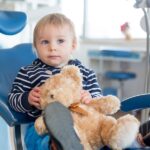 child in dental chair holding comfort item, dental anxiety