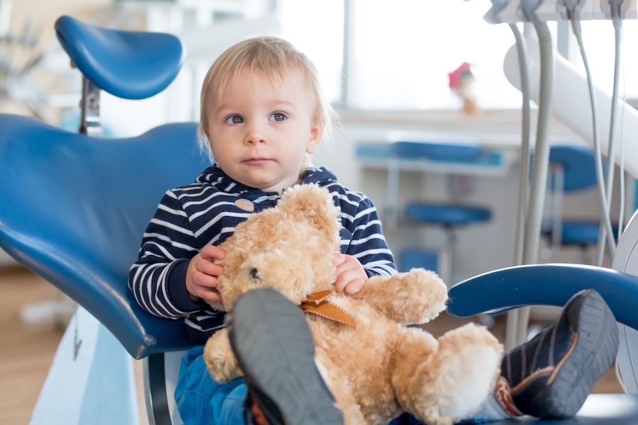 child in dental chair holding comfort item, dental anxiety