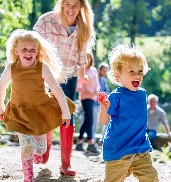 young boy and girl running around outside